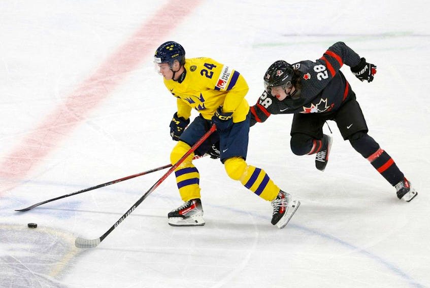 Sweden's Tom Willander (left) and Canada's Conor Geekie vie for the puck during the Group A ice hockey match between Canada and Sweden of the IIHF World Junior Championship in Gothenburg, Sweden on Dec. 29, 2023. 