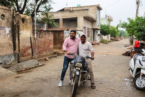 Vishnu Dabad, 30, a Gau Rakshak or a cow protector and politician with the regional political party Jannayak Janta Party(JJP), greets a person on a motorbike, in Chamdhera village, Haryana, India, November 10, 2023.