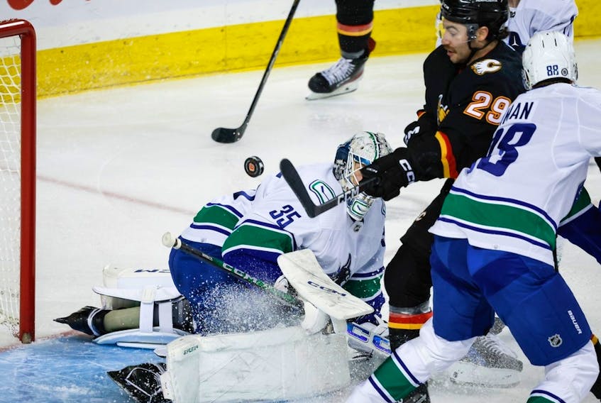 Calgary Flames forward Dillon Dube tries to swat the puck into the net as Vancouver Canucks goalie Thatcher Demko looks on at the Scotiabank Saddledome in Calgary on Saturday, Dec. 2, 2023. Dube did not score on the play.