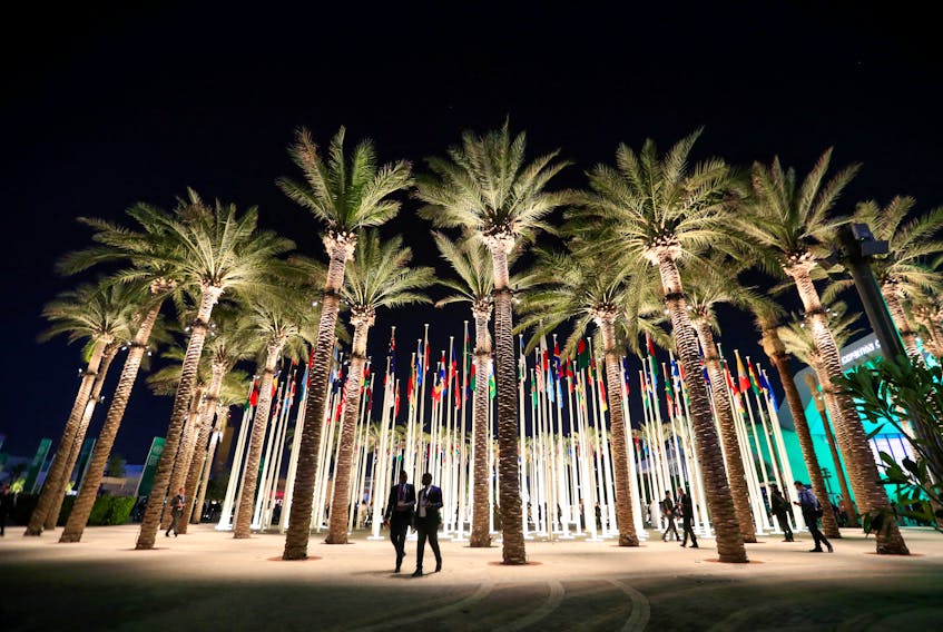 Delegates walk past flag posts at the Dubai's Expo City after attending the World Climate Action Summit, during the United Nations Climate Change Conference (COP28) in Dubai, United Arab Emirates, December 1, 2023.