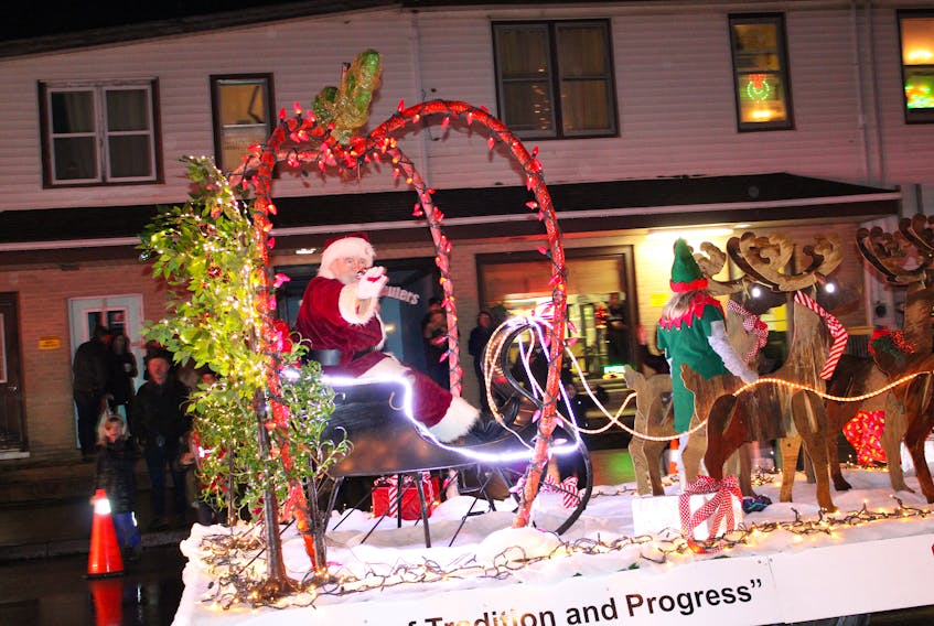 Santa Claus waves to people gathered along Commercial Street in Berwick Dec. 2 for the town’s annual Holiday Parade of Lights.