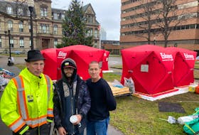 For the past two weeks Steve Wilsack, left, and Matt Grant, far right, have been replacing tents with new heavy-duty shelters at the homeless camp site at Grand Parade in Halifax. They're shown with Michael Baker, who's living in one of the shelters.