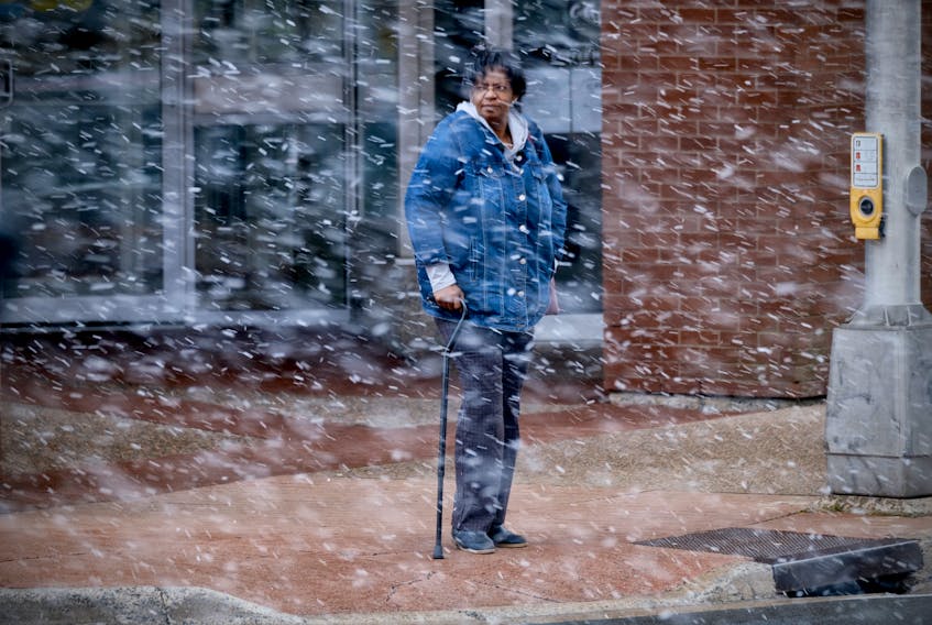 A woman waits to cross the street, during a brief snow squall in Alderney Drive in Dartmouth November 8, 2023.

TIM KROCHAK PHOTO
