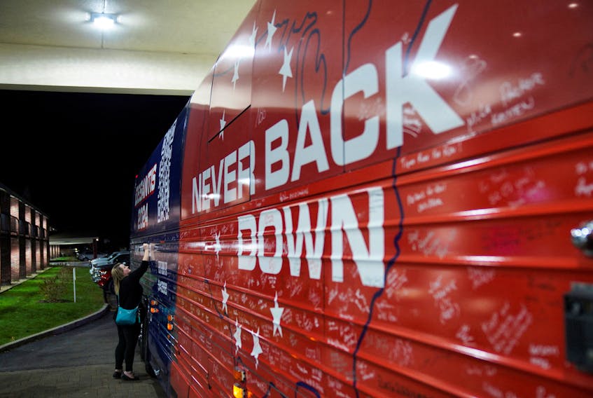 New Hampshire resident Ellie Mooney, 44, signs the campaign bus of Republican presidential candidate Florida Governor Ron DeSantis after a Never Back Down campaign event in Keene, New Hampshire, U.S., on November 21, 2023.