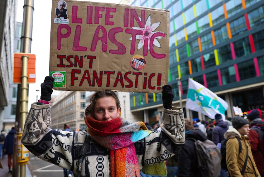 A demonstrator holds a placard, during a climate protest coinciding with COP28 being held in Dubai and ahead of the upcoming Belgian presidency of the Council of the European Union, in Brussels, Belgium, December 3, 2023.