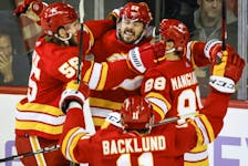 Calgary Flames defenceman MacKenzie Weegar, centre, celebrates his goal with teammates during overtime against the Vegas Golden Knights.