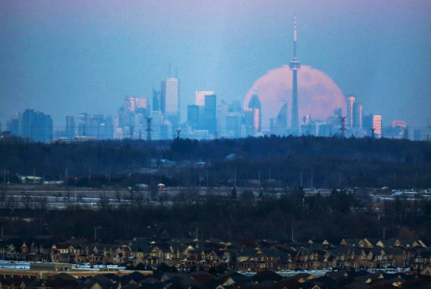 The moon rises over the Toronto city skyline as seen from Milton, Ontario, Canada, January 23, 2016.   
