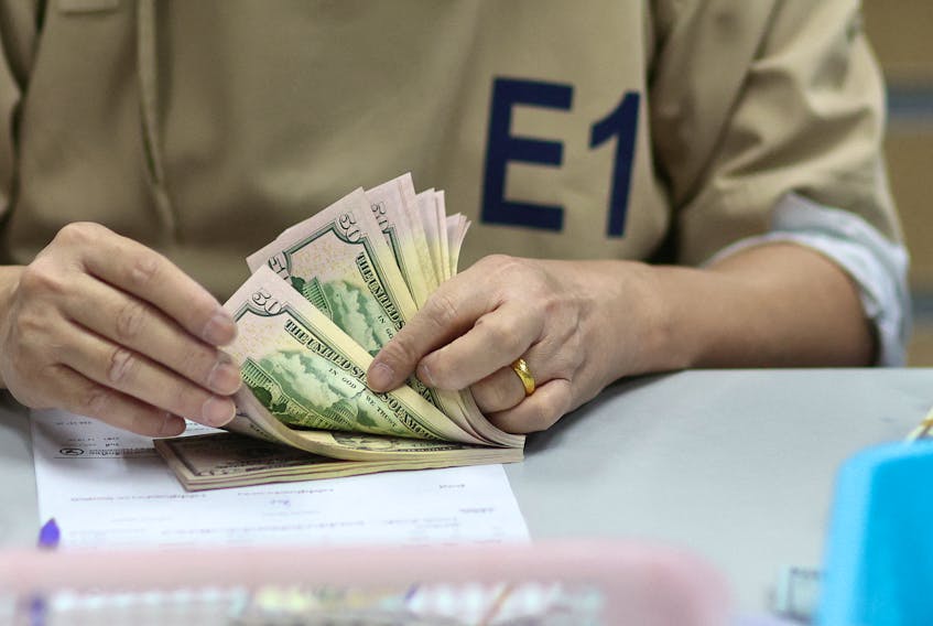 A bank employee counts U.S. dollar notes at a Kasikornbank in Bangkok, Thailand, January 26, 2023.