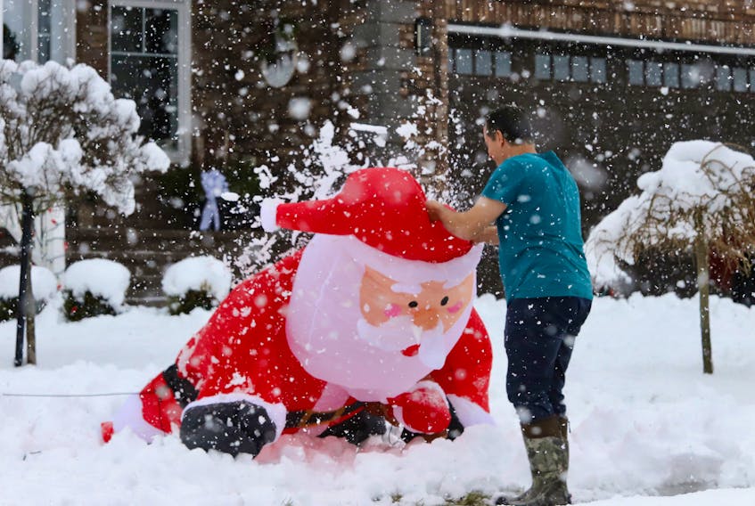 An Astral Drive resident pulls up a an inflatable Santa Claus that had collapsed from the heavy snow, on Colby Village in Dartmouth December 4, 2023.

TIM KROCHAK PHOTO