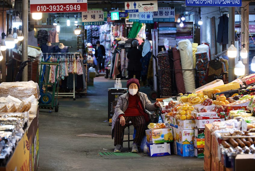 A shopkeeper naps as she waits for customers at a traditional market in Seoul, South Korea, April 7, 2022.