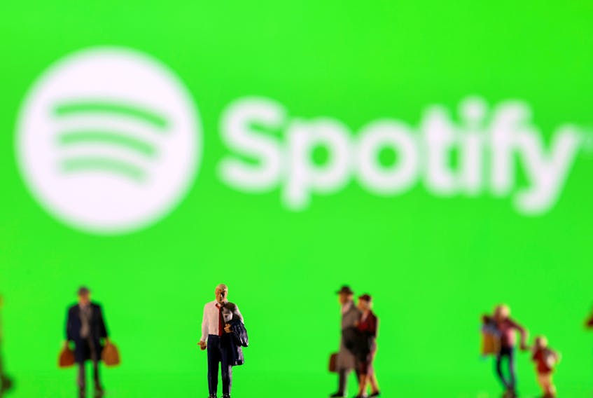Small figurines are seen in front of displayed Spotify logo in this illustration taken February 11, 2022.
