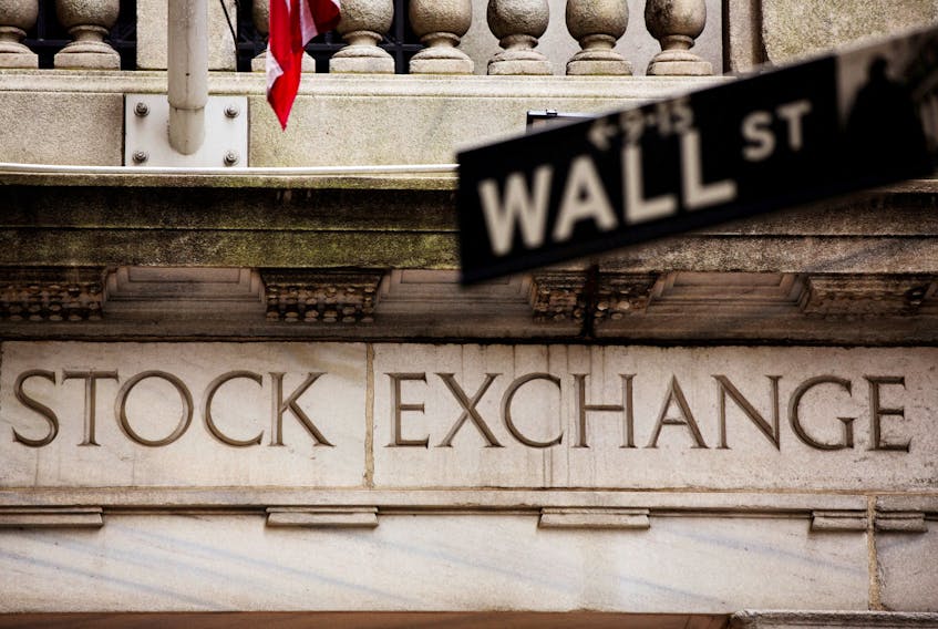 A street sign for Wall Street hangs in front of the New York Stock Exchange May 8, 2013.