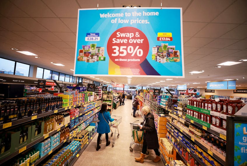 Shoppers push trolleys along an aisle inside an ALDI supermarket near Altrincham, Britain, February 20, 2023.