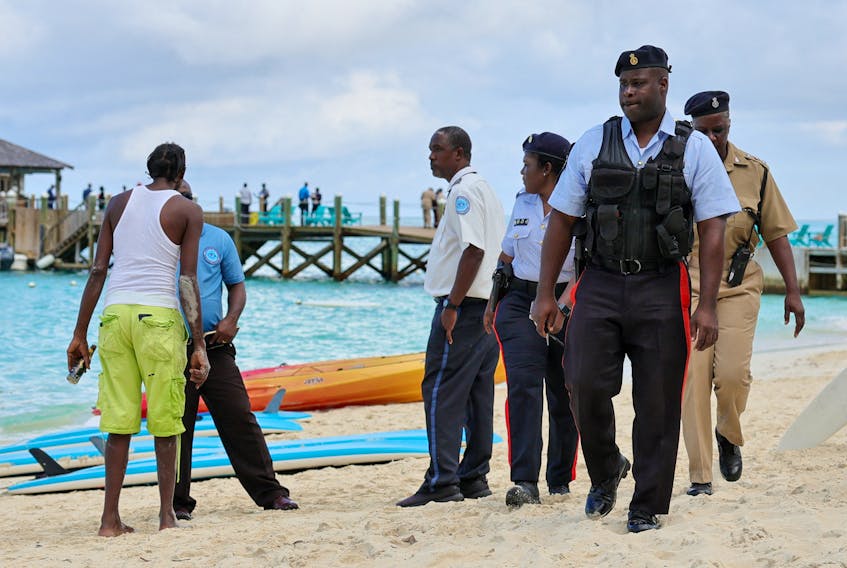 Police officers walk on the beach after what police described as a fatal shark attack against a tourist at Sandals Royal Bahamian resort, in Nassau, Bahamas December 4, 2023. 