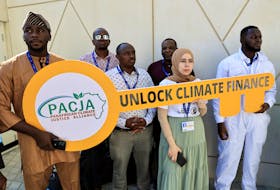 Activists hold a sign that reads "Unlock Climate Finance" during a protest, at the United Nations Climate Change Conference COP28 in Dubai, United Arab Emirates, December 5, 2023.