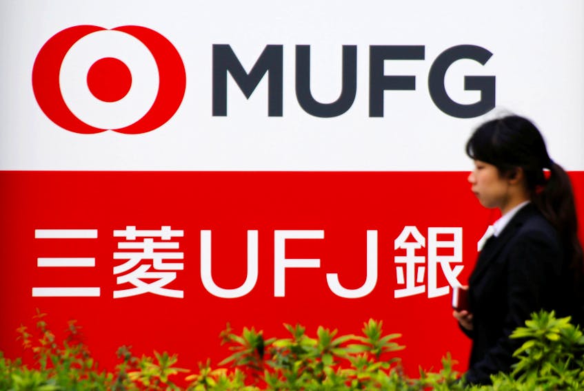 A woman walks past a signboard of MUFG Bank in Tokyo, Japan April 3, 2018.