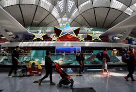 Travellers walk past an installation in the shape of five stars, at Beijing Daxing International Airport in Beijing, China April 24, 2023.