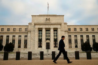 A man walks past the Federal Reserve in Washington, December 16, 2015.