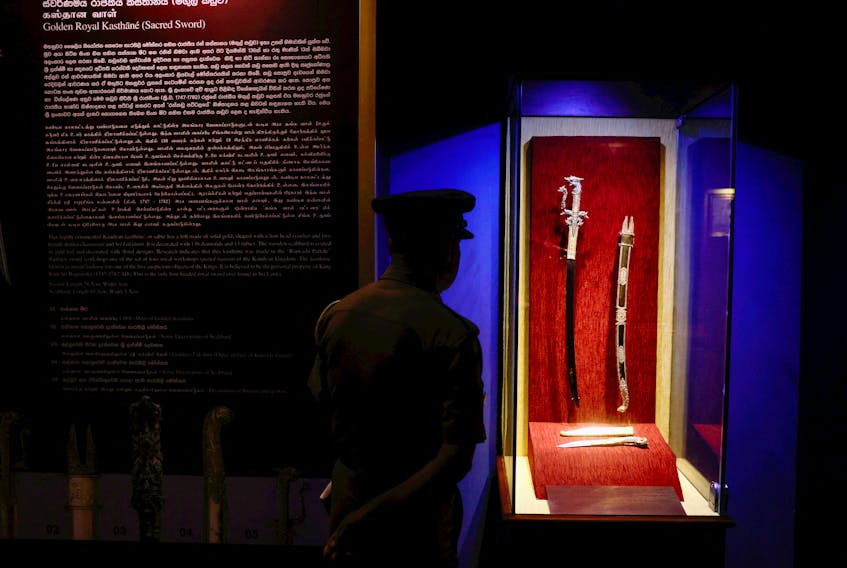 A policeman views colonial-era artefacts that have been returned from the Netherlands, at the main Museum in Colombo, Sri Lanka December 5, 2023.