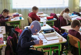 Roman, 8, wounded by Russian missile strike on the central Ukrainian city of Vinnytsia last year, attends a lesson at school, with his face covered by a burn mask, after a year of skin grafts and over 30 surgeries, in Lviv, Ukraine December 4, 2023. 