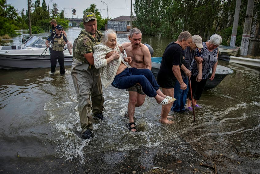 Rescuers evacuate local residents from a flooded area after the Nova Kakhovka dam breached, amid Russia's attack on Ukraine, in Kherson, Ukraine June 7, 2023.