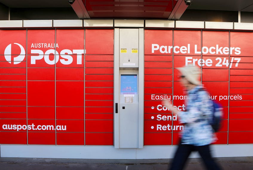 A woman walks past Australia Post parcel lockers in Sydney, Australia, February 8, 2018.