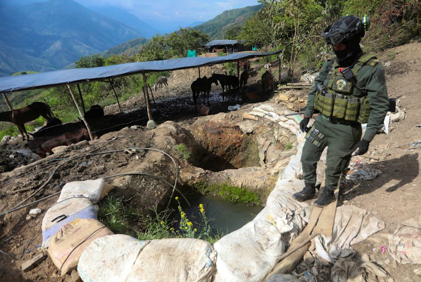 A policeman stands next to a well where minerals taken from illegal gold mines are washed in Buritica, Colombia April 20, 2021. 