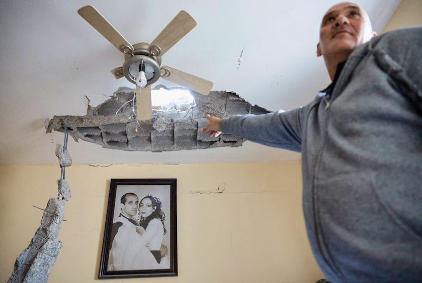 A man points at damage inside a building at a site hit by a rocket fired from Gaza today, amid the ongoing conflict between Israel and the Palestinian Islamist group Hamas, in Ashkelon, Israel, December 5, 2023.
