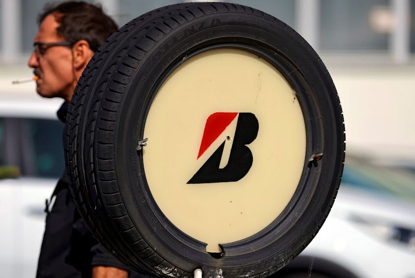 A worker walks past a tyre with Bridgestone's logo at the company's tyre plant in Bethune, that Japan's Bridgestone plans to shut, France, September 17, 2020. Picture taken September 17, 2020.