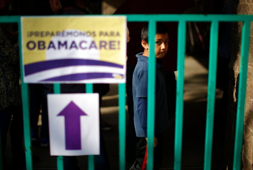 A boy waits in line at a health insurance enrollment event in Cudahy, California March 27, 2014. 