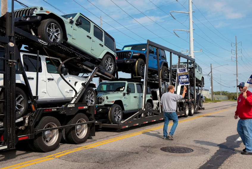 A car hauler transporting  Jeep Wranglers drives past striking United Auto Workers members outside the Stellantis Jeep Plant in Toledo, Ohio, U.S. September 17, 2023.