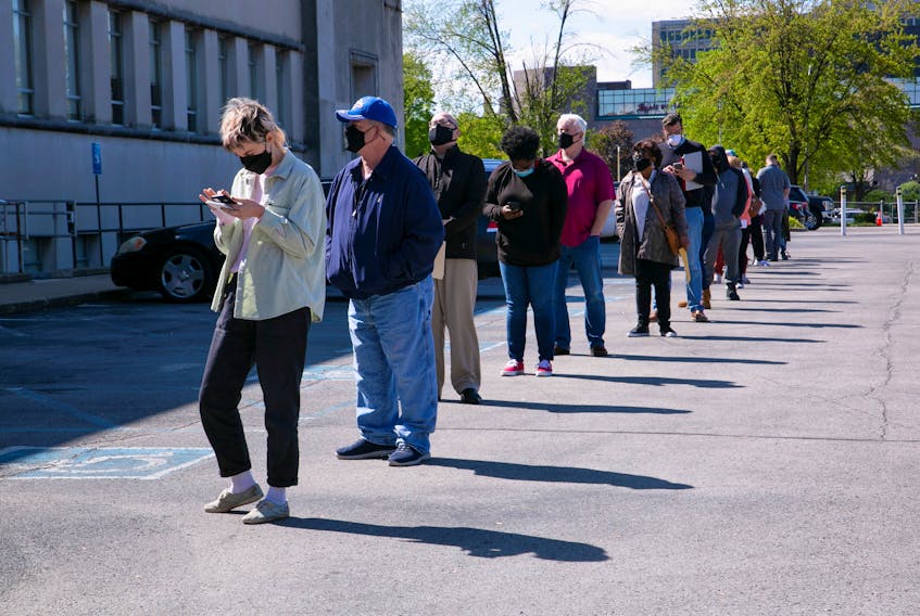 People line up outside a newly reopened career center for in-person appointments in Louisville, U.S., April 15, 2021. 