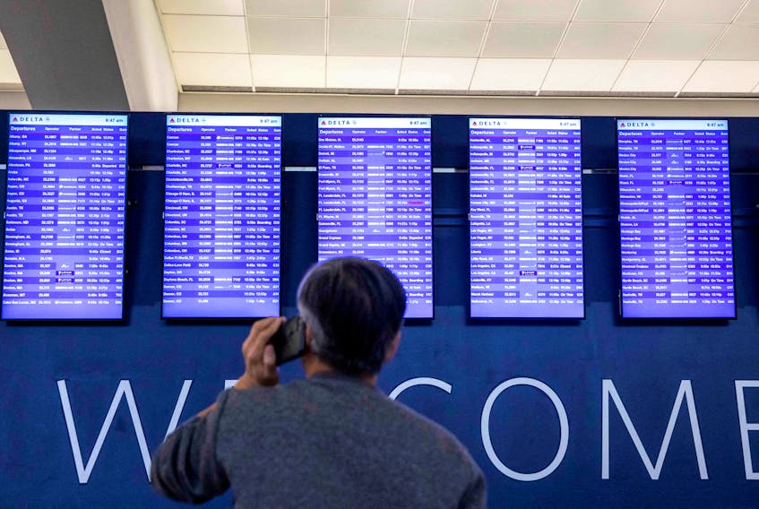 A passenger checks their flight status at Hartsfield-Jackson Atlanta International Airport after the Federal Aviation Administration (FAA) had ordered airlines to pause all domestic departures due to a system outage in Atlanta, Georgia, U.S., January 11, 2023.