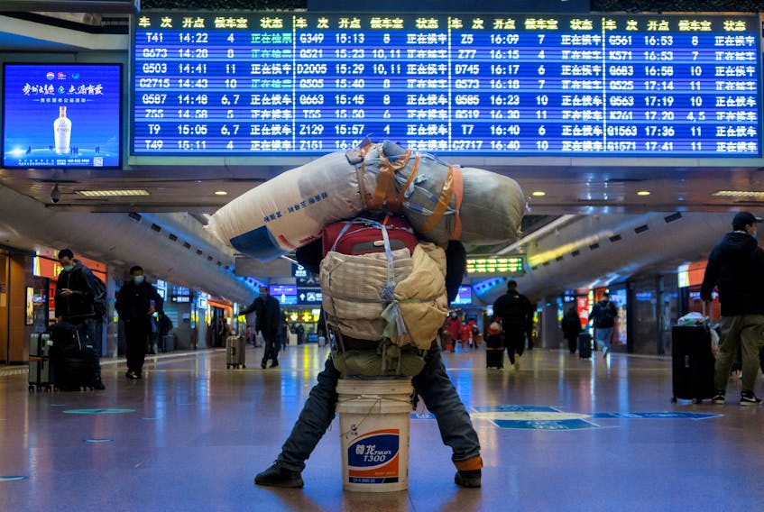 A traveller is seen with his belongings at a railway station, following the coronavirus disease (COVID-19) outbreak, in Beijing, China January 13, 2021. Picture taken January 13, 2021.