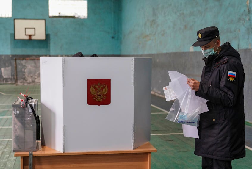 A Russian serviceman studies ballots at a polling station, which is  placed in a sport hall, during a three-day parliamentary election in the village of Ryabinovka in Kaliningrad region, Russia September 18, 2021.