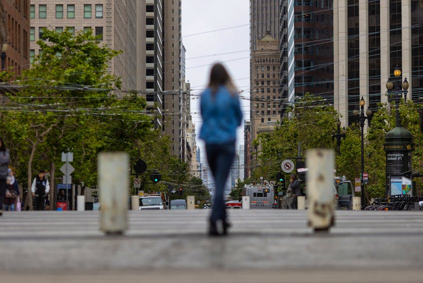 A woman walks along Market street in downtown San Francisco as the city struggles to return to its pre-pandemic downtown occupancy rate, falling behind many other major cities around the country, according to local media, in California, U.S., June 27, 2023. 