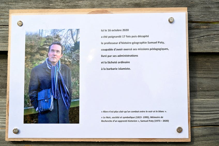 A photograph taken on October 16, 2023 shows a commemorative plaque for slain teacher Samuel Paty (portrait) near the Bois d'Aulne school in Conflans-Sainte-Honorine, outside Paris.  BERTRAND GUAY/Pool via
