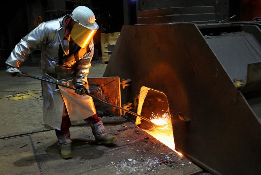 A steel worker in heat protection gear takes a sample of raw iron from Europe’s largest furnace with a daily raw iron production of 12,000 tons, at the steel plant of ThyssenKrupp in Duisburg, Germany, November 16, 2023. 