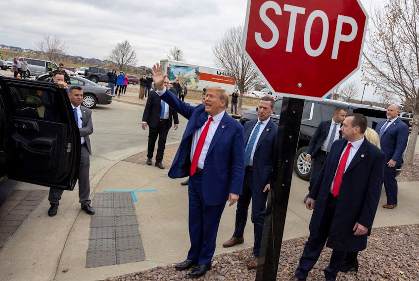 Former U.S. President and Republican presidential candidate Donald Trump gestures as he leaves after attending a rally with supporters at a "commit to caucus" event at a Whiskey bar in Ankeny, Iowa, U.S. December 2, 2023.