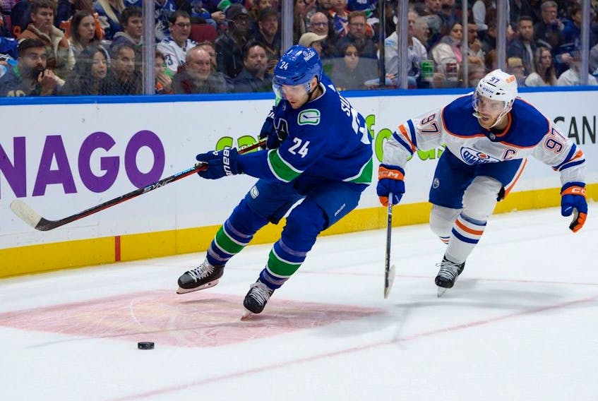 Pius Suter #24 of the Vancouver Canucks is pursued by Connor McDavid #97 of the Edmonton Oilers during the first period of their NHL game at Rogers Arena on October 11, 2023 in Vancouver, British Columbia, Canada.