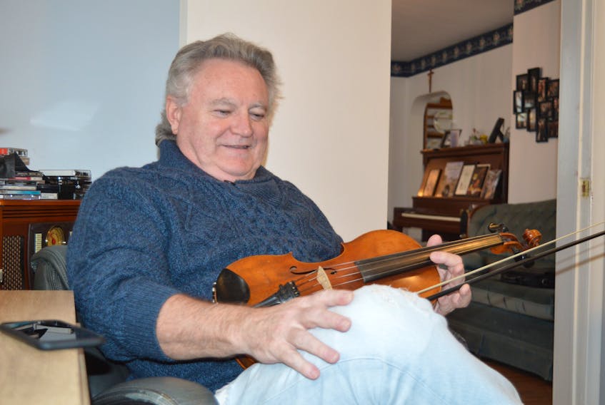Cape Breton fiddler Howie MacDonald is shown at his home in Westmount. The music room where he is sitting will become office space for his Celtic Counselling business, which is a new career path since concluding his masters in counselling psychology. GREG MCNEIL/CAPE BRETON POST