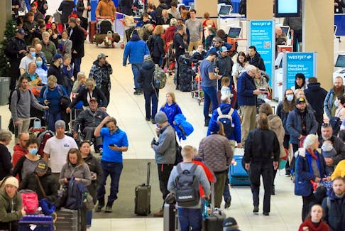 Hundreds of WestJet passengers line up as they wait to rebook cancelled flights at the Calgary International Airport on December 20, 2022.