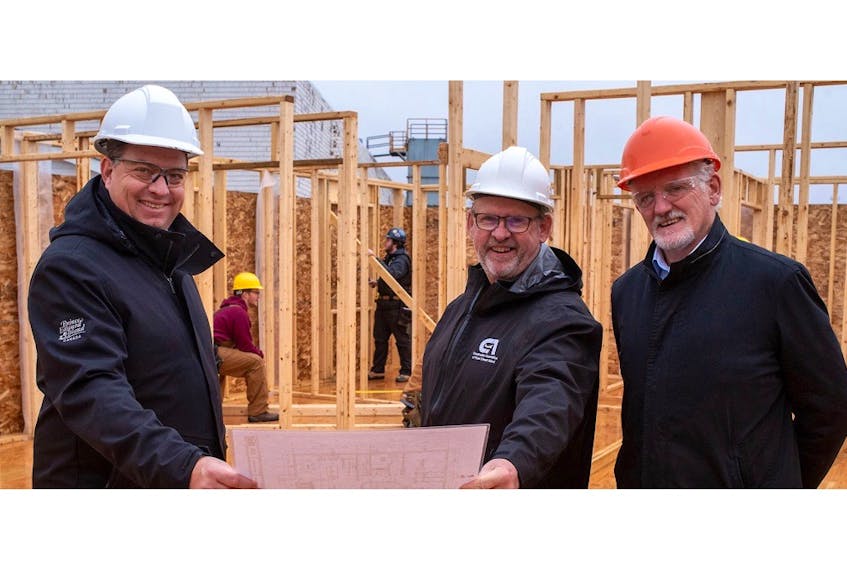 Social Development and Housing Minister Matthew MacKay, left, Construction Association of P.E.I. general manager Sam Sanderson and Holland College president Sandy MacDonald with students from Holland College carpentry program working on a new home. Contributed