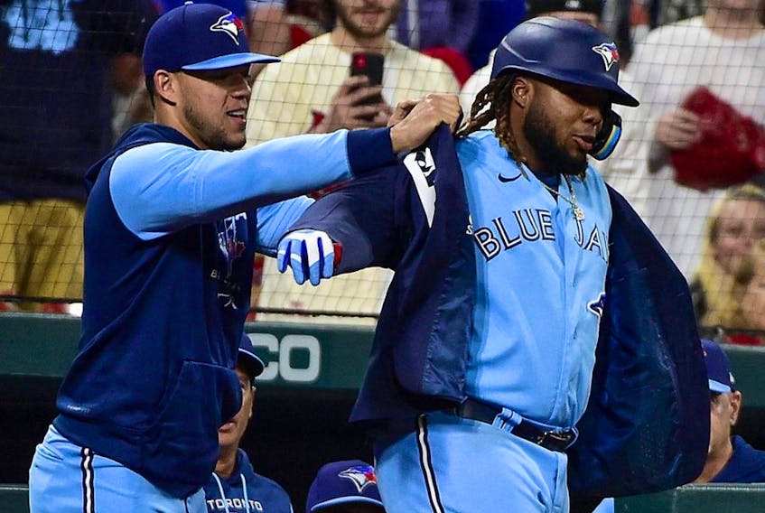 Blue Jays first baseman Vladimir Guerrero Jr. (right) receives the home run jacket from pitcher Jose Berrios (left) after hitting a solo homer against the Cardinals during sixth inning MLB action at Busch Stadium in St. Louis, May 24, 2022.