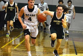 Cohen McDonald of the Breton Education Centre Bears, left, dribbles the ball up the court as he's chased by Ben Madden of the Strait Area Education Recreation Centre Saints of Port Hawkesbury during New Waterford Coal Bowl Classic action at the BEC gym in New Waterford on Wednesday. BEC won the game 78-41. JEREMY FRASER/CAPE BRETON POST