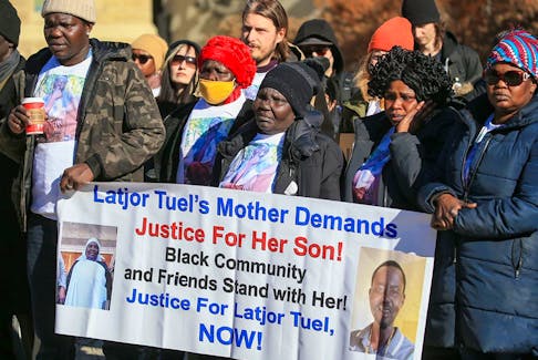 Family and friends of Latjor Tuel, including his mother, Rebecca Aker Akol (centre), call for justice at Calgary City Hall on the first anniversary of his death on Sunday, Feb. 19, 2023. Tuel was killed by police on Feb. 19, 2022 along 17th Avenue S.E. during a mental health crisis.