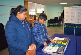 Sherin Jose, left, and her son, Yahaan Jacob, right, of South Bar are pictured looking at an exhibit at the Discovery Centre event hosted by the James McConnell Memorial Library in Sydney on Saturday. "(Yohaan) is really interested in science. He is so interested in rockets and things like that."