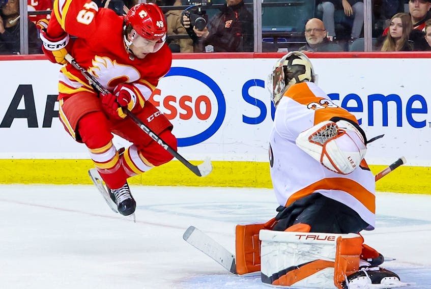  Flames forward Jakob Pelletier leaps in front of Philadelphia Flyers goaltender Samuel Ersson during Monday’s game.