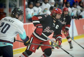 Northwest Territories defenceman Matthew MacKay tries to tie up Yukon winger Gavin McKenna off a faceoff during action Feb. 20 at the Canada Games hockey tournament in Charlottetown.
Jason Malloy