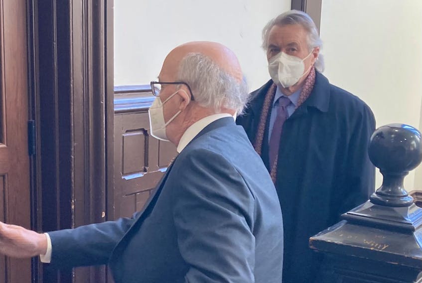 Former Chester-St. Margarets MLA Hugh Wilson MacKay, right, enters Halifax provincial court with lawyer Don Murray on Wednesday, Feb. 22, 2023. MacKay, 68, pleaded guilty to a charge of impaired driving from an incident in November 2018 and received a $1,000 fine and one-year driving prohibition.